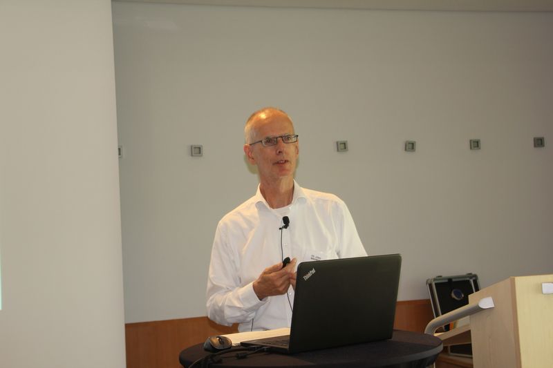 Dr. Jörg Wagner hält einen Vortrag am Laptop, mit Ansteckmikrofon